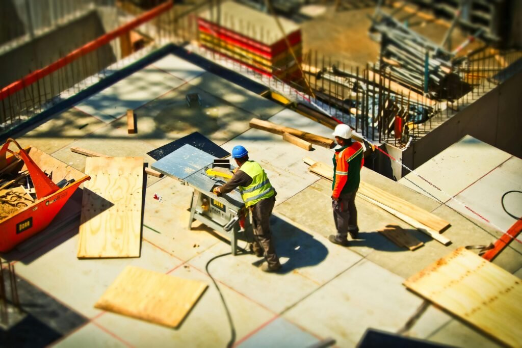 construction-site-build-construction-work-159306-159306 Construction workers engaging in tasks at an outdoor building site with safety hats and equipment.